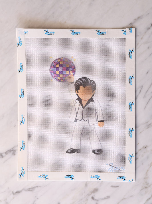 Cross-stitched design of a person with a colorful mirror ball on a white fabric background.