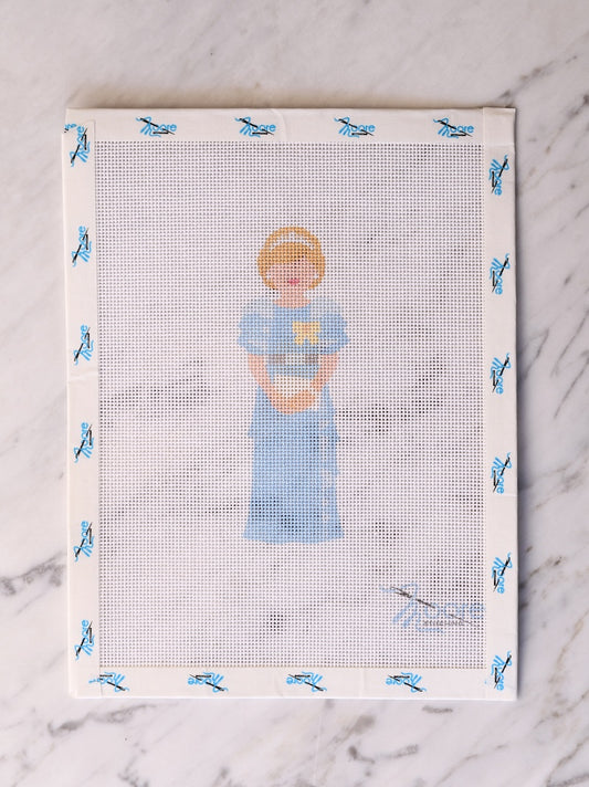 Cross-stitched design of a child holding a teddy bear on fabric with blue butterfly pattern.