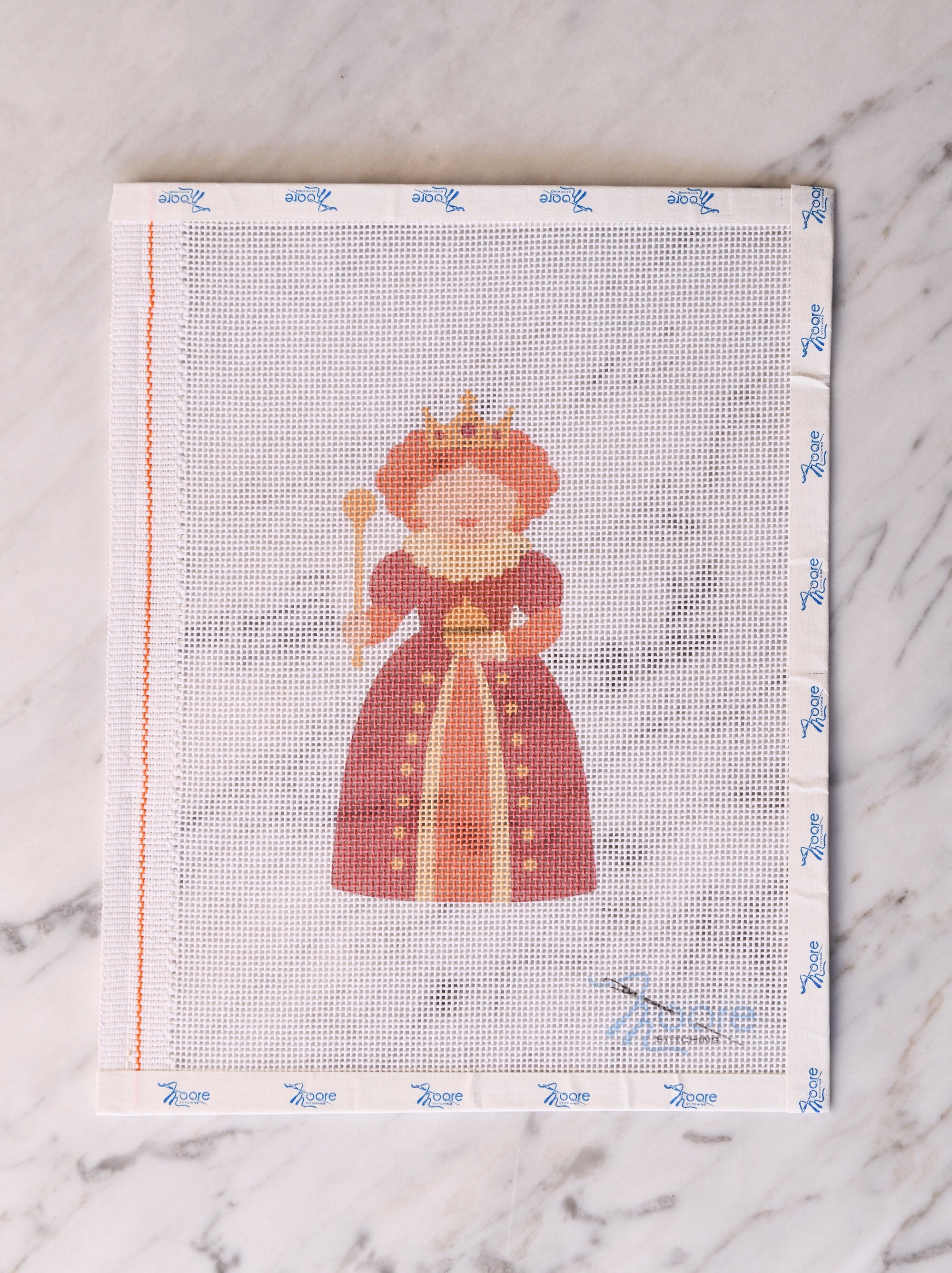Cross-stitch pattern with a queen design on a fabric swatch.