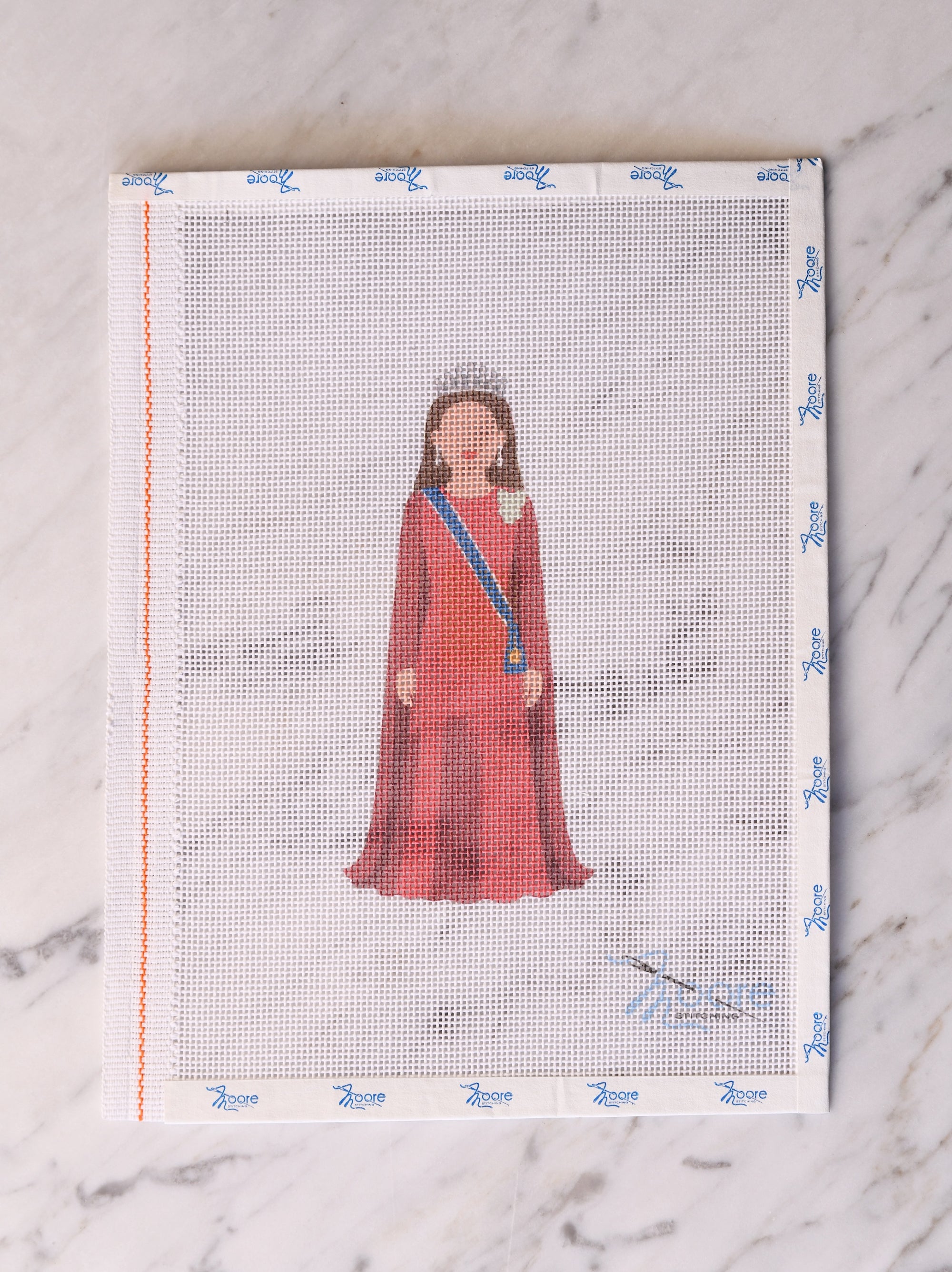 Cross-stitch pattern with a princess in a red dress on a white fabric background