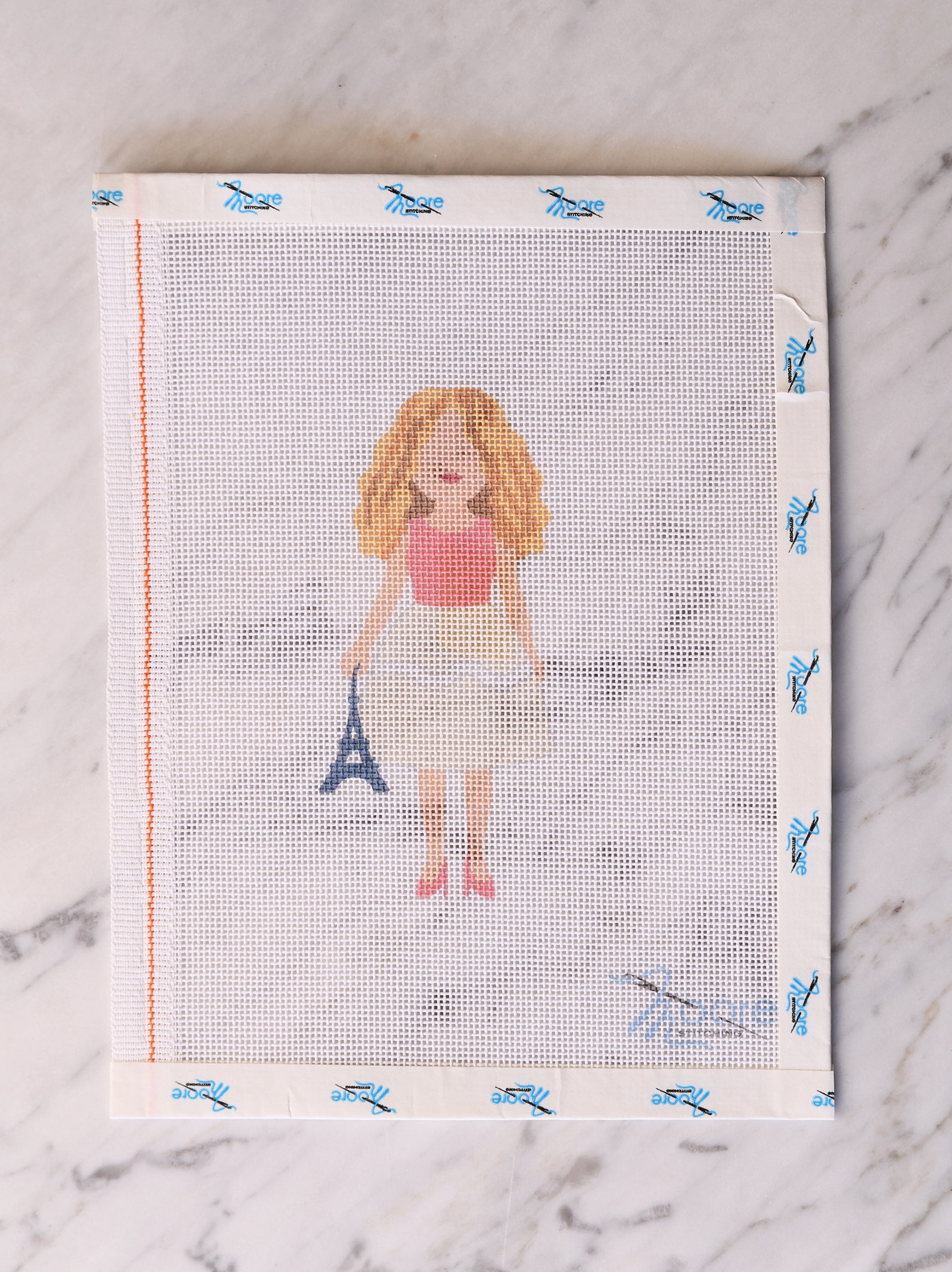 Fabric with a printed design of a woman holding the Eiffel Tower.